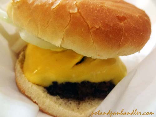 Fresh beef burgers are topped generously with fake cheese.
